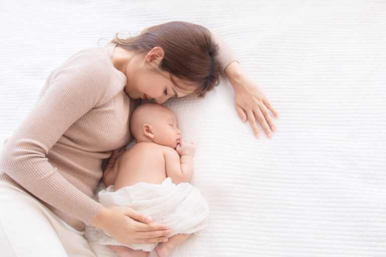 Asian beautiful mom motherhood lie down nursing, kissing newborn