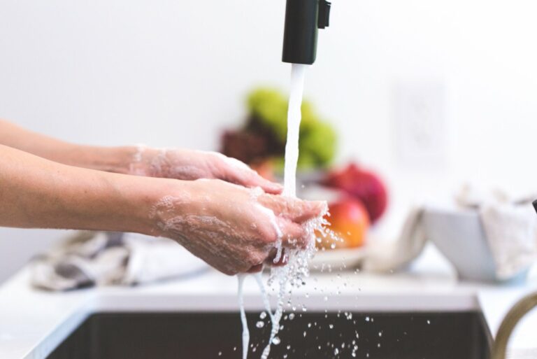 Hands Lathering Soap And Washing Hands In The Kitchen Sink