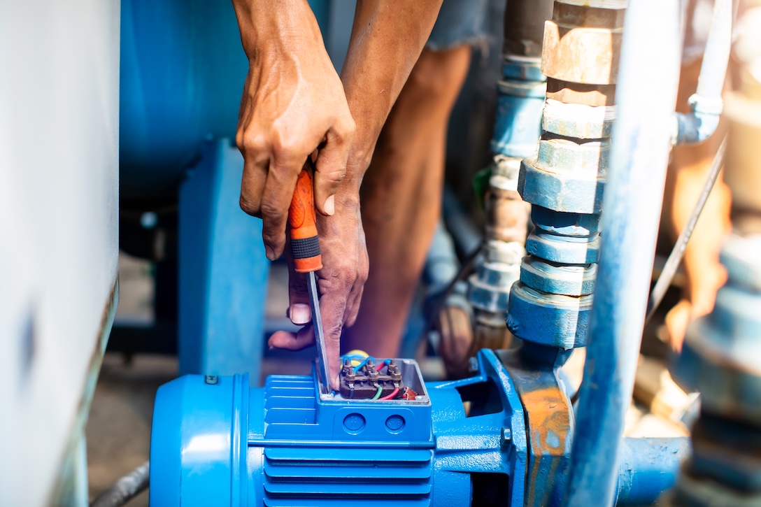 Selective focus to hand of plumber repair and remove motor of centrifugal water pump. Plumbers working to installation centrifugal water pump motor. 